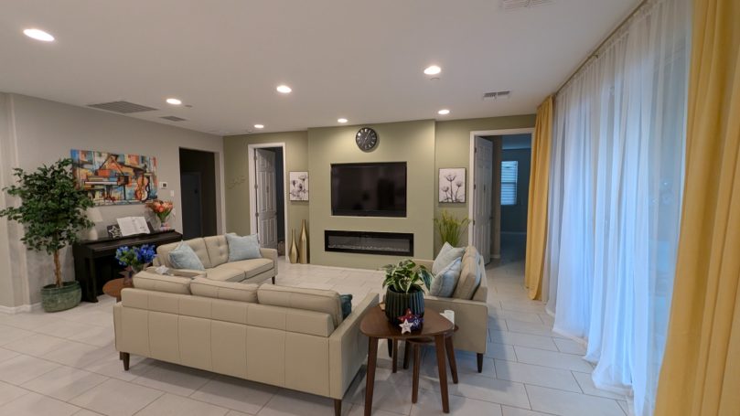 Living Room Bright, comfortable living room at Desert Willow Memory Care with fireplace, large television, comfortable seating, and natural light.